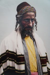 From the Yemenite Museum, a photo of a Jewish man wearing the side-curls required by the Muslim majority of the minority Jewish population, that began immigrating to Israel in the late 1800’s